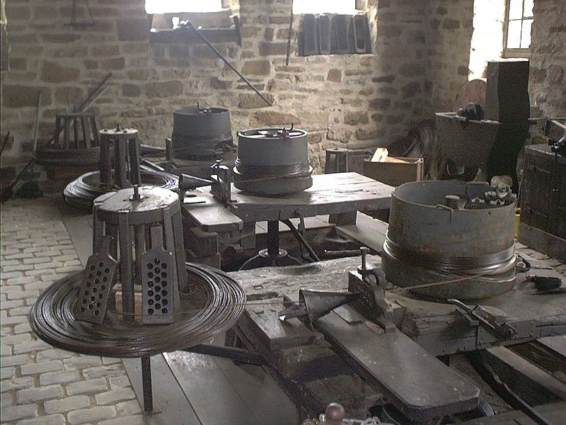 Antiga máquina utilizada para produzir arame, mostrando várias fieiras